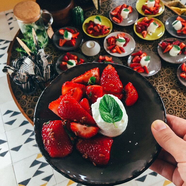 A plate of fresh strawberries and plant-based dishes